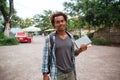 Smiling man with backpack standing and holding books outdoors Royalty Free Stock Photo