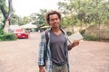 Smiling man with backpack standing and holding books outdoors Royalty Free Stock Photo