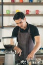 Smiling man barista with apron making coffee in his small cafe Royalty Free Stock Photo