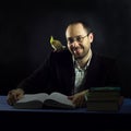 Smiling man and bird on shoulder learning books