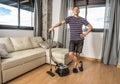 Smiling man vacuuming the living room Royalty Free Stock Photo