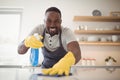 Smiling man cleaning the kitchen worktop Royalty Free Stock Photo