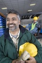 Smiling Man With Colleague Behind In Factory Royalty Free Stock Photo