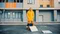 Smiling man courier in yellow clothes delivers food - pizza boxes on the floor