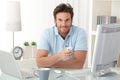 Smiling man at desk with mobile phone Royalty Free Stock Photo