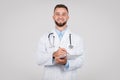 Smiling man doctor with stethoscope writing on clipboard Royalty Free Stock Photo