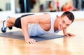 Smiling man doing push-ups in the gym