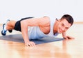 Smiling man doing push-ups in the gym