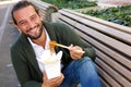 Smiling man eating fast food noodles with chopsticks Royalty Free Stock Photo