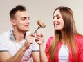 Smiling man feeding happy woman with cake.