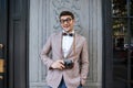 Smiling man in funny round glasses holding vintage photo camera Royalty Free Stock Photo