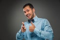 Smiling man is gesturing with hand, pointing finger at camera Royalty Free Stock Photo