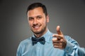 Smiling man is gesturing with hand, pointing finger at camera Royalty Free Stock Photo