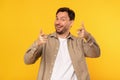 Smiling Man Giving Double Thumbs Up Against Bright Yellow Background
