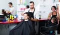 hairdresser cutting hair of female client. Royalty Free Stock Photo