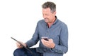 Smiling man happy handsome businessman looking using tablet computer while texting phone Royalty Free Stock Photo
