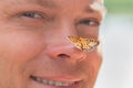 Man has a butterfly on his nose