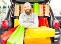 Smiling man having fun with lots of bags on a shopping day for the black friday Royalty Free Stock Photo