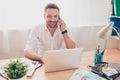 Smiling man having talk with his clients and working on laptop Royalty Free Stock Photo