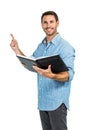 Smiling man holding a book and pointing up Royalty Free Stock Photo