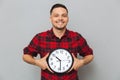 Smiling man holding clock in hands Royalty Free Stock Photo