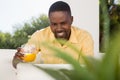 Smiling man holding juice glass while looking at laptop Royalty Free Stock Photo