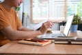 Smiling man holding notebook and using laptop computer a home. Royalty Free Stock Photo