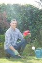Smiling man holding pot plant in garden Royalty Free Stock Photo