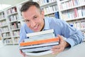 Smiling man holding stack books Royalty Free Stock Photo