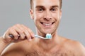 Smiling man holding toothbrush with toothpaste and cleaning his teeth Royalty Free Stock Photo