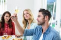 Smiling man holding white wine glass with friends Royalty Free Stock Photo