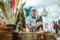 smiling man holds the clipboard while list items among craft items Royalty Free Stock Photo