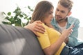 Smiling man hugging depended girlfriend with smartphone Royalty Free Stock Photo