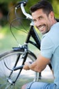 smiling man inflating bicycle tyre Royalty Free Stock Photo