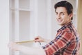 Smiling Man Installing Furniture in New Home.