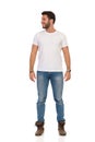 Smiling Man In Jeans And White T-shirt Is Standing And Looking Away. Front View Royalty Free Stock Photo