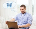 Smiling man with laptop shopping online at home Royalty Free Stock Photo