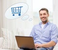 Smiling man with laptop shopping online at home Royalty Free Stock Photo