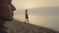 Smiling man looking sea landscape at sunrise. Positive guy sitting on beach Royalty Free Stock Photo