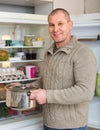 Smiling man with pan near fridge Royalty Free Stock Photo