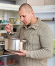 Smiling man with pan near fridge Royalty Free Stock Photo