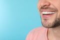 Smiling man with perfect teeth on color background, closeup. Royalty Free Stock Photo