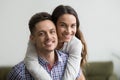 Smiling man piggyback cheerful wife looking at camera