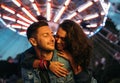 Smiling man piggybacks his happy girlfriend at the festival