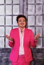 Smiling man in pink suit stands against old icy door Royalty Free Stock Photo