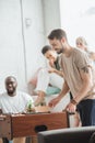 smiling man playing table football while friends