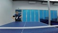 Smiling man playing the table tennis at the court