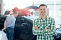 Smiling man posing near car with arms crossed. Royalty Free Stock Photo