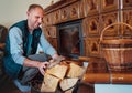 Smiling man putting wood logs in the home mantel fire.Home sweet home and winter countryside holidays concept image Royalty Free Stock Photo