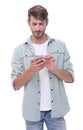 Smiling man reading an SMS on the smartphone Royalty Free Stock Photo